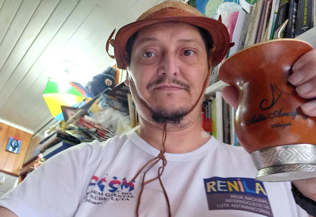 #ParaTodesVerem: Roque Junior em sua biblioteca, veste um chapéu e toma chimarrão